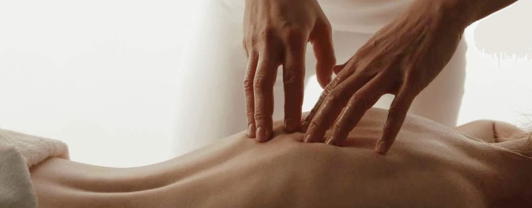 Mains massant le dos d'une femme