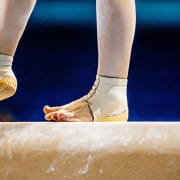 A gymnasts feet on the bar