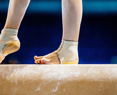 A gymnasts feet on the bar